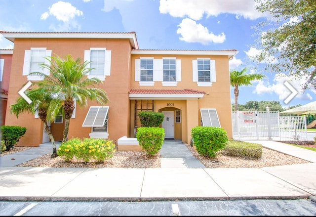 1000 Park Club Dr, Kissimmee, FL 34746 - view of front of property with stucco siding, a tiled roof, fence, and a gate
