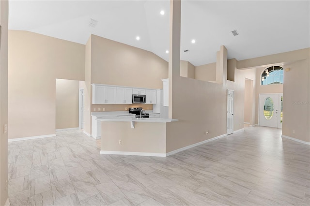 9885 Montclair Cir, Apopka, FL 32703 - kitchen featuring light countertops, high vaulted ceiling, appliances with stainless steel finishes, and open floor plan