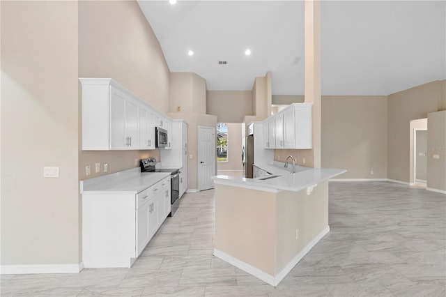 9885 Montclair Cir, Apopka, FL 32703 - kitchen featuring appliances with stainless steel finishes, light countertops, high vaulted ceiling, marble finish floor, and a peninsula