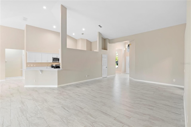 9885 Montclair Cir, Apopka, FL 32703 - spare room featuring baseboards, a sink, visible vents, and high vaulted ceiling