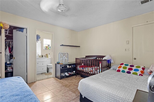 1828 Matterhorn Dr, Orlando, FL 32818 - tiled bedroom with visible vents, a textured ceiling, and ensuite bathroom