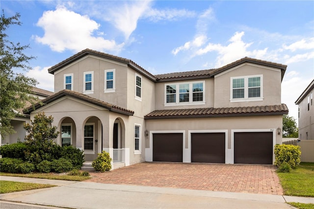 9567 Meadow Hunt Way, Winter Garden, FL 34787 - mediterranean / spanish-style house with a garage, covered porch, decorative driveway, stucco siding, and a tiled roof