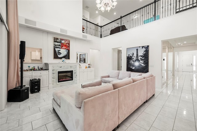 9567 Meadow Hunt Way, Winter Garden, FL 34787 - living area with visible vents, a tiled fireplace, light tile patterned floors, a notable chandelier, and a high ceiling