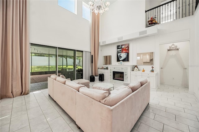 9567 Meadow Hunt Way, Winter Garden, FL 34787 - living area with light tile patterned flooring, a notable chandelier, a glass covered fireplace, a towering ceiling, and visible vents