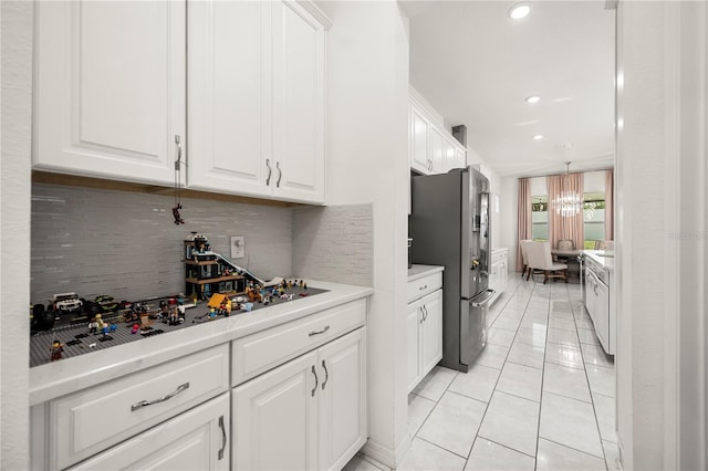 9567 Meadow Hunt Way, Winter Garden, FL 34787 - kitchen featuring tasteful backsplash, light tile patterned floors, light countertops, white cabinets, and freestanding refrigerator