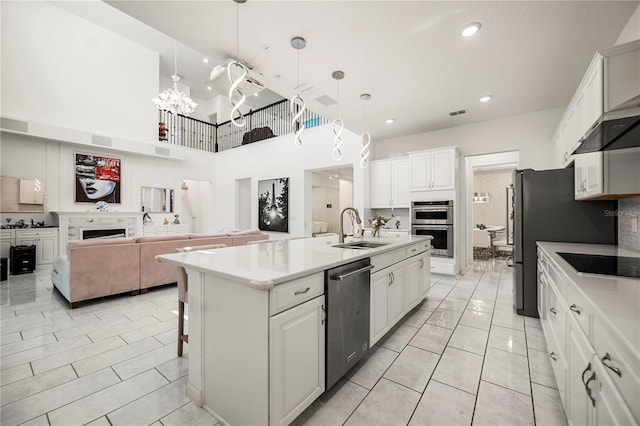 9567 Meadow Hunt Way, Winter Garden, FL 34787 - kitchen featuring a kitchen island with sink, appliances with stainless steel finishes, a sink, open floor plan, and white cabinetry
