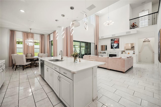 9567 Meadow Hunt Way, Winter Garden, FL 34787 - kitchen with a center island with sink, light countertops, a sink, white cabinets, and an inviting chandelier