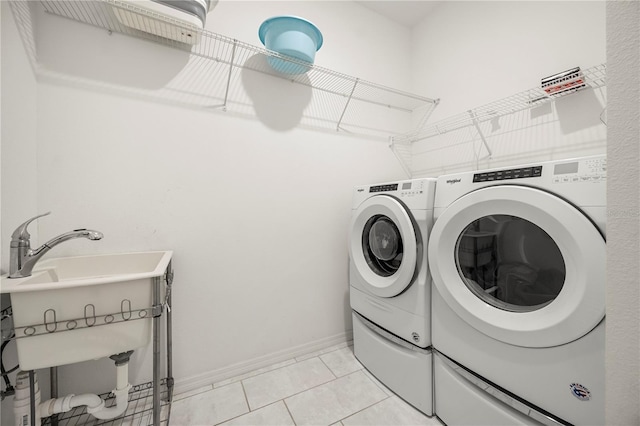 9567 Meadow Hunt Way, Winter Garden, FL 34787 - washroom with laundry area, washing machine and dryer, light tile patterned floors, baseboards, and a sink