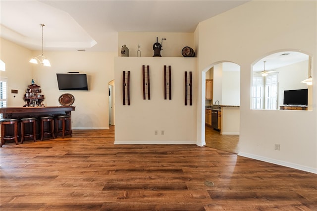 27127 Stoney Brook Dr, Leesburg, FL 34748 - empty room with a ceiling fan, wood finished floors, arched walkways, baseboards, and a bar