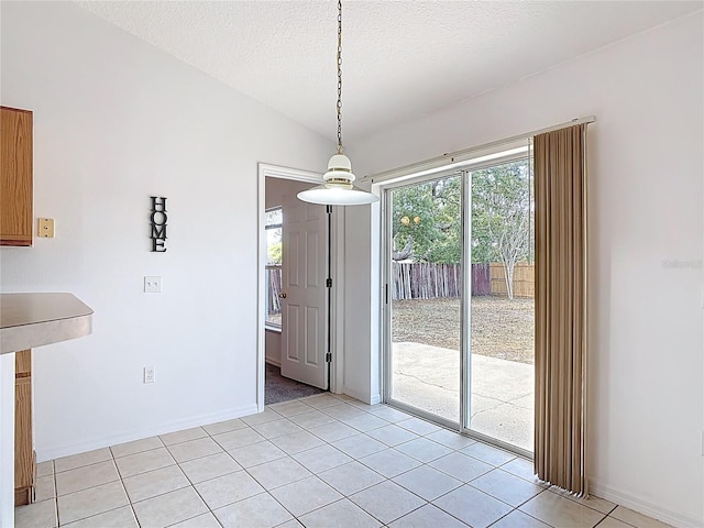 unfurnished dining area featuring light tile patterned floors and baseboards