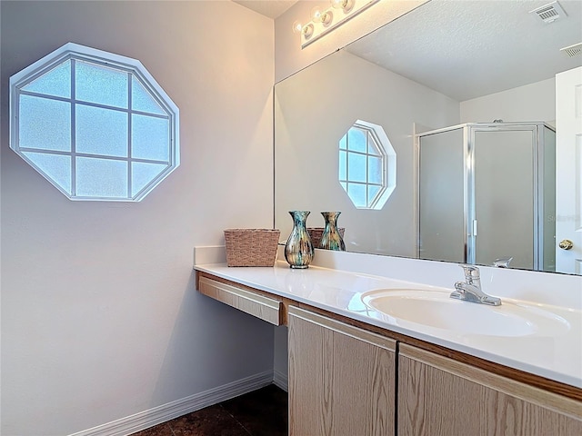 bathroom with visible vents, tile patterned flooring, vanity, baseboards, and a stall shower