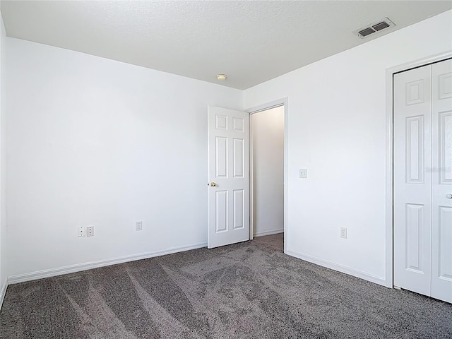 unfurnished bedroom with carpet flooring, baseboards, visible vents, and a closet