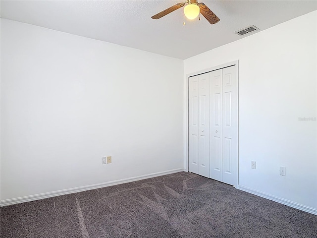 unfurnished bedroom featuring ceiling fan, visible vents, baseboards, a closet, and dark carpet