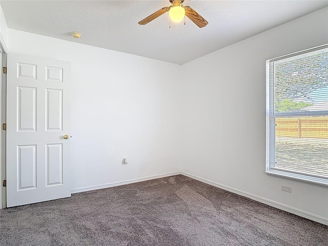 carpeted spare room with baseboards and a ceiling fan