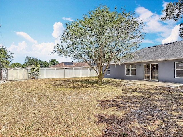 view of yard featuring fence, an outdoor structure, a patio area, and a shed