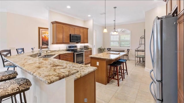 871 Iron Oak Way, The Villages, FL 32163 - kitchen featuring brown cabinetry, a peninsula, a kitchen breakfast bar, a sink, and appliances with stainless steel finishes