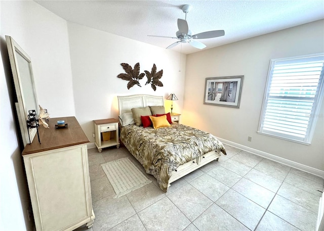 871 Iron Oak Way, The Villages, FL 32163 - bedroom with baseboards, a ceiling fan, a textured ceiling, and light tile patterned floors