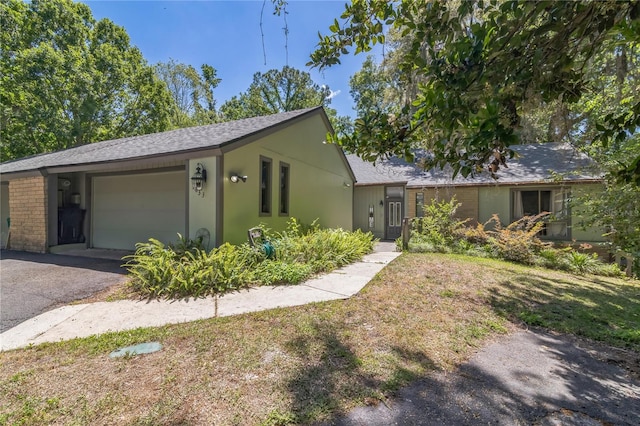 ranch-style house with driveway, a shingled roof, and a garage
