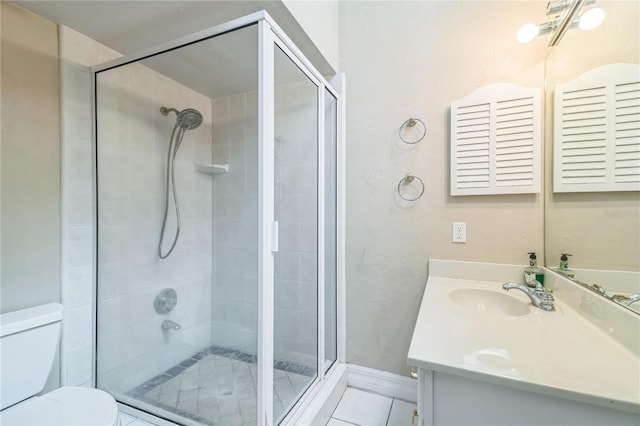 full bathroom featuring vanity, tile patterned floors, a shower stall, and toilet