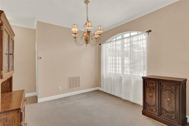 spare room featuring light colored carpet, a chandelier, crown molding, and baseboards
