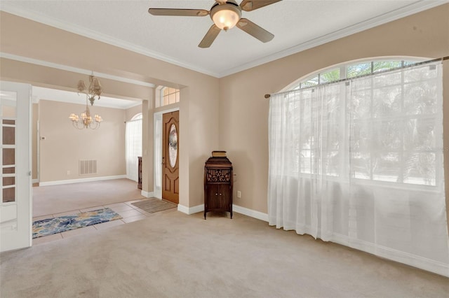 entrance foyer with a chandelier, carpet, ornamental molding, ceiling fan, and tile patterned floors