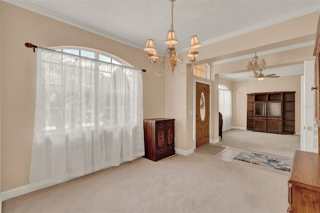 entryway with healthy amount of natural light, carpet floors, a chandelier, ornamental molding, and a textured ceiling
