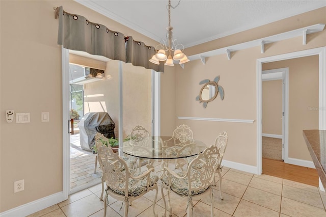 tiled dining space featuring a chandelier and baseboards