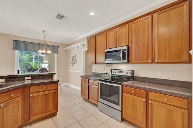 kitchen featuring stainless steel appliances, dark countertops, a chandelier, light tile patterned floors, and a textured ceiling