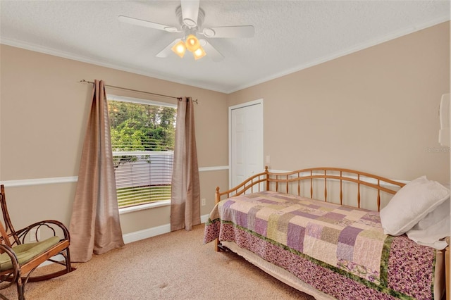 carpeted bedroom featuring a textured ceiling, ornamental molding, and ceiling fan