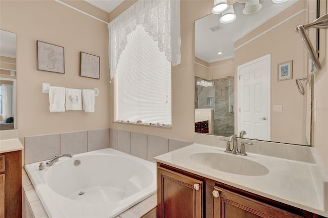 bathroom with ornamental molding, a shower stall, a garden tub, and vanity