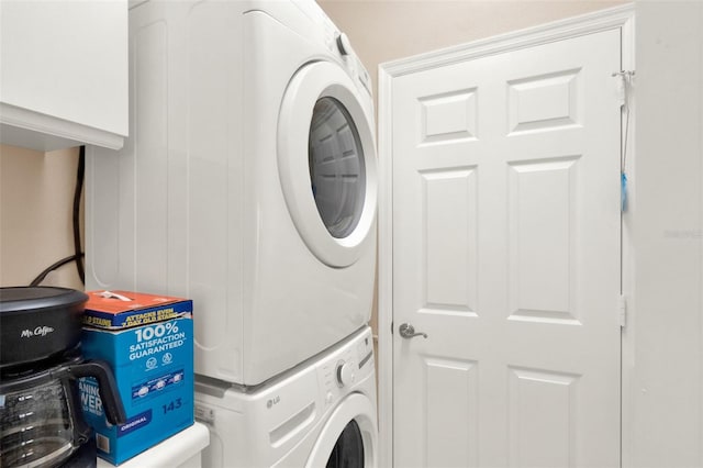 clothes washing area with estacked washer and dryer