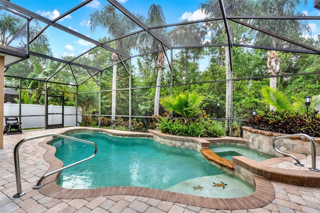 view of pool featuring a pool with connected hot tub, glass enclosure, and a patio area