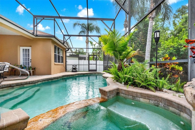 view of pool with an in-ground hot tub, a patio area, and a lanai