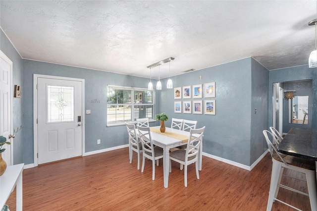 6801 16th St N, Saint Petersburg, FL 33702 - dining room featuring an inviting chandelier, wood finished floors, a textured ceiling, visible vents, and baseboards