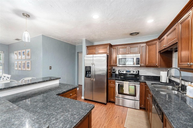 6801 16th St N, Saint Petersburg, FL 33702 - kitchen with light wood-style flooring, a sink, brown cabinetry, visible vents, and appliances with stainless steel finishes