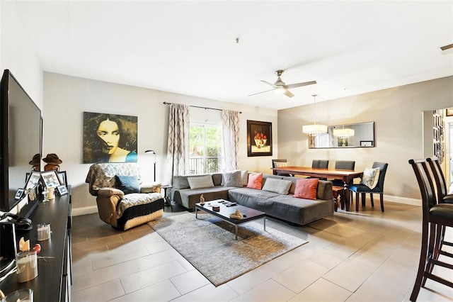 living room with baseboards, a ceiling fan, and visible vents