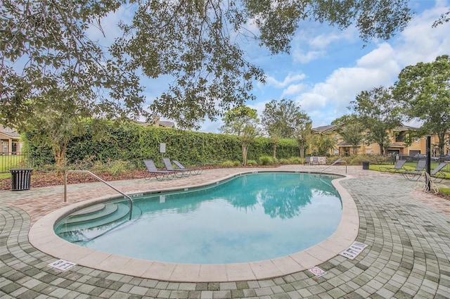 community pool featuring a patio and fence