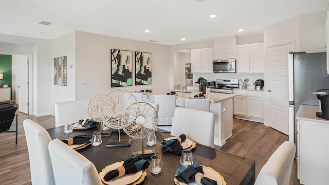 dining room with light wood-style floors, recessed lighting, and visible vents