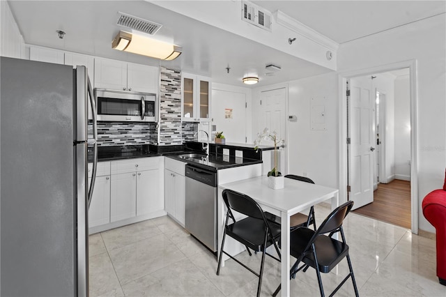 kitchen featuring stainless steel appliances, visible vents, decorative backsplash, and a sink