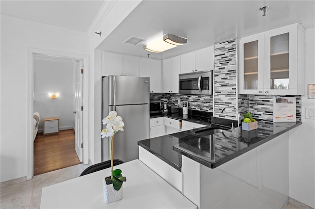 kitchen with backsplash, appliances with stainless steel finishes, a sink, and visible vents