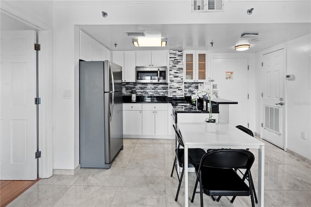 kitchen featuring stainless steel appliances, visible vents, and white cabinetry
