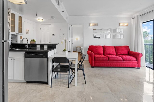 kitchen featuring a sink, dark countertops, stainless steel appliances, and a healthy amount of sunlight