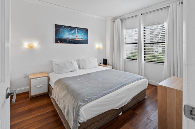 bedroom with dark wood-type flooring, ornamental molding, and baseboards