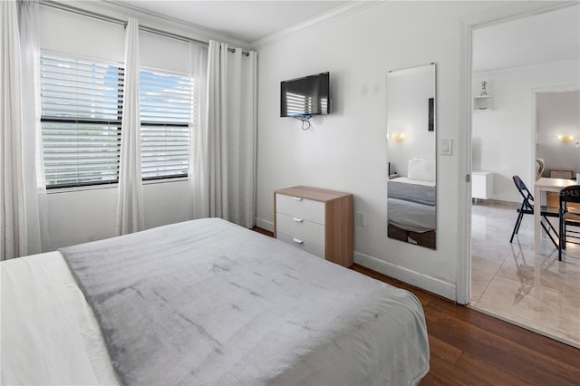 bedroom with baseboards, dark wood-style floors, ornamental molding, and multiple windows