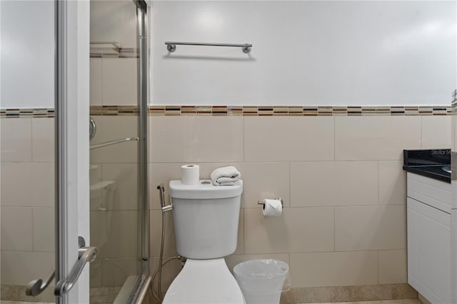 bathroom featuring vanity, tile walls, a stall shower, and toilet