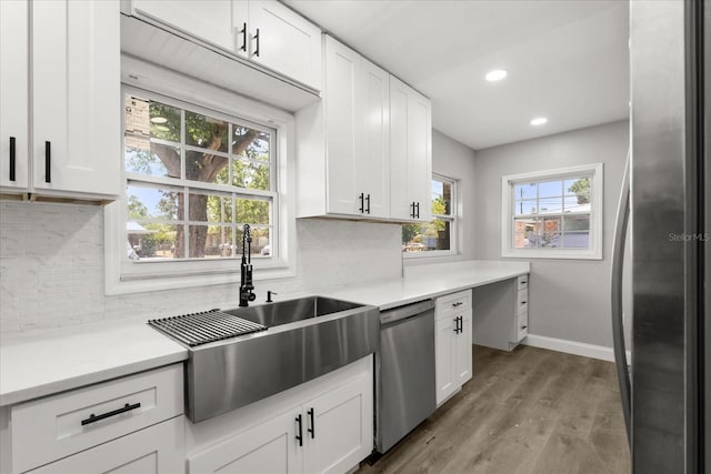 2014 10th St NW, Winter Haven, FL 33881 - kitchen with white cabinets, appliances with stainless steel finishes, a sink, and tasteful backsplash