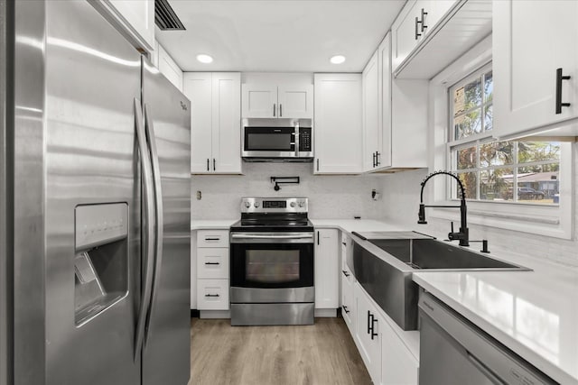 2014 10th St NW, Winter Haven, FL 33881 - kitchen with backsplash, appliances with stainless steel finishes, a sink, and light countertops