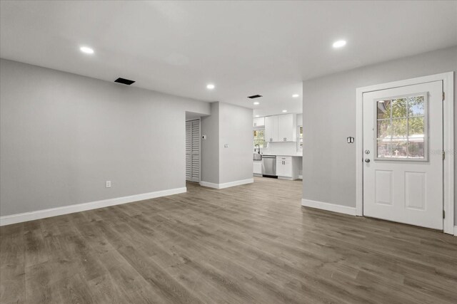 2014 10th St NW, Winter Haven, FL 33881 - unfurnished living room with recessed lighting, baseboards, and wood finished floors