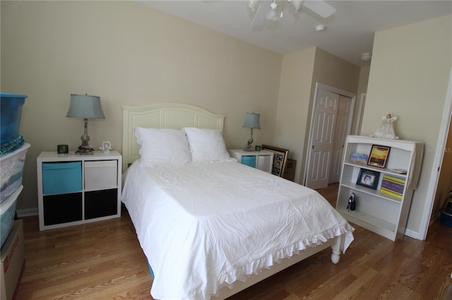 bedroom with a ceiling fan, wood finished floors, and a closet
