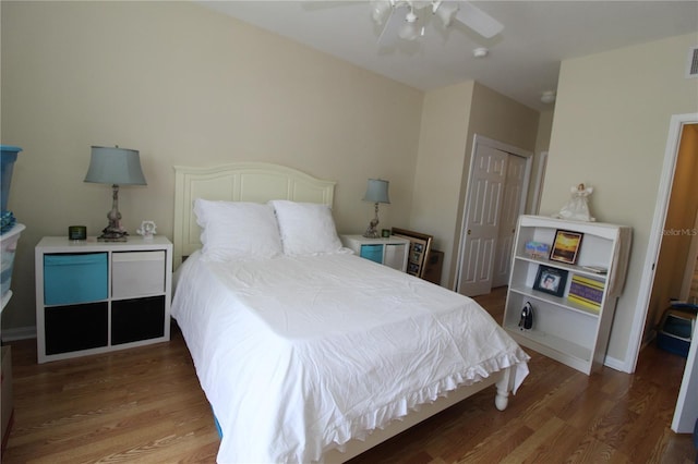 bedroom featuring a closet, a ceiling fan, wood finished floors, and visible vents